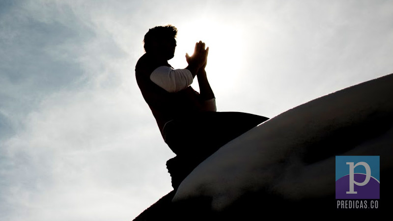 Hombre orando a Dios en la cima de una montaa